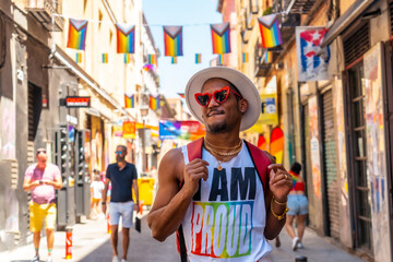 Obraz na płótnie Canvas A gay black ethnicity man enjoying and smiling at the pride party, LGBT flag