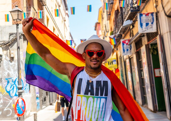 Fototapeta na wymiar Portrait of a gay black man walking at the pride party with an LGBT flag