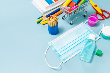 School supplies, poppit anti-stress, face mask, bottle of sanitizer, for back to school on a blue...