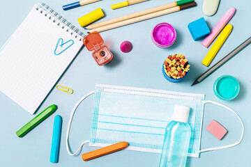 School supplies, poppit anti-stress, face mask, bottle of sanitizer, for back to school on a blue...