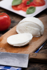 Fototapeta na wymiar Fresh mozarella cheese on cutting board