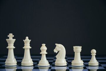 All suits white chess pieces on chess board.