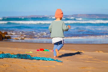 little girl is playing on the beach in portugal algarve