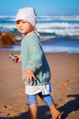 little girl is playing on the beach in portugal algarve