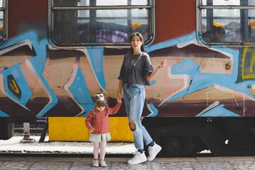 portrait of a mother with her daughter in love with graffiti train