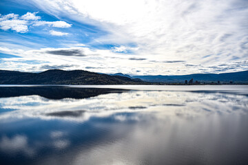 Fototapeta na wymiar Clouds on lake and mountains