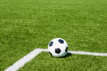 Fototapeta na wymiar Soccer ball on green synthetic artificial grass soccer sports field with white corner stripe line