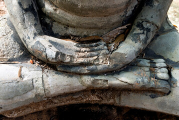 Close-up of o broken statue of Buddha in lotus pose