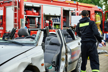 Firefighters during a rescue operation training. Rescuers unlock the passenger in car after accident. Katy Wroclawskie, Poland - May 28, 2022