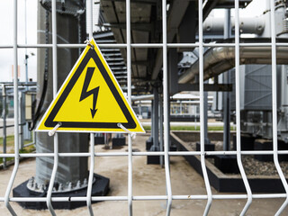 Danger Sign High voltage in a yellow triangle on a metal grid