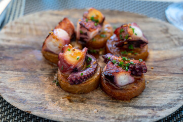Spanish starter in fish restaurant in Getaria, grilled octopus with roasted potatoes and paprika, Basque Country, Spain