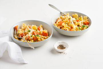 Italian pasta Mafalda Corta trafilata al bronzo with sauteed sweet potato, fennel, parmesan grated cheese on white background. Vegetarian meatless food. No people.