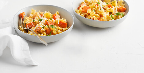 Italian pasta Mafalda Corta trafilata al bronzo with sauteed sweet potato, fennel, parmesan grated cheese on white background. Vegetarian meatless food. Empty space for text, no people.