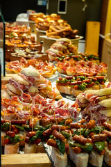 Typical snack of Basque Country and Navarre, pinchos or pinxtos, small piece of bread with different toppings, served in bar, Bilbao, Spain