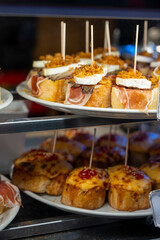 Typical snack of Basque Country and Navarre, pinchos or pinxtos, small piece of bread with different toppings, served in bar, Bilbao, Spain