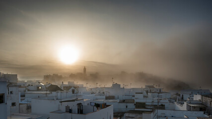 Fototapeta premium Spanish village on a foggy morning. Beautiful Andalusian Pueblo Blanco (white village) at sunrise. Vejer de la Frontera is one of the most beautiful Pueblos Blancos, Cádiz province, Andalusia, Spain.