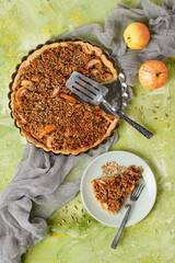 Apple tart with sunflower seeds on a green background. Top view of serving for the homemade sweet pastry recipe