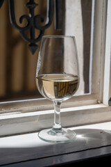 Tasting of white grand cru classe chablis wine with old French houses on background, Burgundy, France