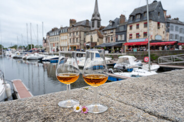 Tasting of apple calvados drink in old Honfleur harbour with boats and old houses on background, Normandy, France - obrazy, fototapety, plakaty