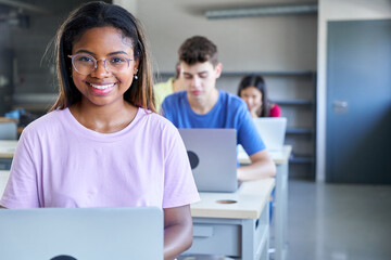 Smiley copy space portrait of African american young woman looking at camera while studying at the...