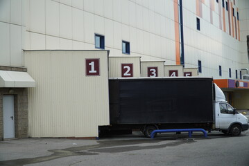 unloading a truck near the gates of a warehouse or shopping center