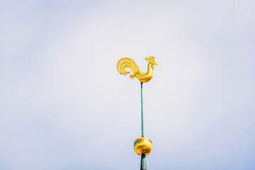 Symbol of old Riga town in Latvia - golden cockerel (rooster) topping bell tower of Riga Doms...