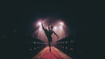 Graceful hard-working ballerina dancing i in spotlight. Silhouette   Diligent ballet dancer performing dancing elements of classical ballet. Slow motion.