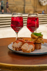 Glasses of cold sangria wine served outdoor with pinchos in bar with view on old street in San Sebastian, Basque Country, Spain