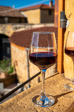 Tasting of red wine by old wine maker in Pierres Dor&eacute;es region with yellow stone houses on south of Beaujolais region, France