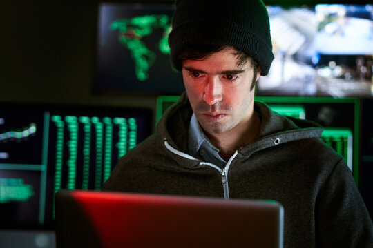 Dangerous Hooded Hackers Breaks into Government Data Servers and Infects Their System with a Virus. His Hideout Place has Dark Atmosphere, Multiple Displays, green light