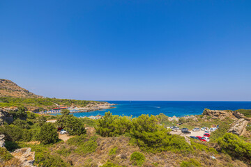 Fototapeta na wymiar Beautiful panoramic landscape view of island on dark blue sea water merging with cloudless sky on background. Rhodes. Greece. 