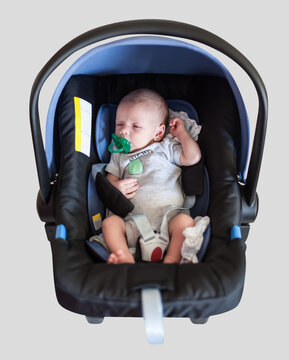 Cute little peaceful baby in his egg shell stroller car seat. Clipping path and white background