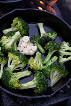 Outdoor camp cooking on cast iron pans with an open  wood burning flame