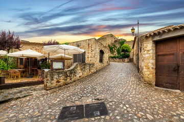 The medieval Spanish village of Pals, Spain, with a sidewalk cafe on it's cobbled damp streets...