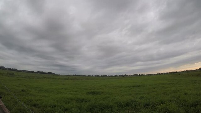 Time lapse of convective clouds with a smooth base moving over the observer in the Dutch polder landscape.