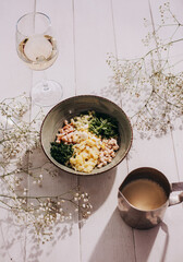 Bowl with different ingredients for okroshka on white wooden background
