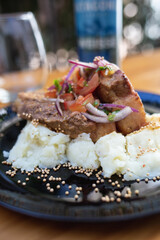 dish with meat, mashed potatoes and vegetables, glass and beer on the table