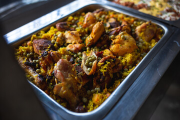 metal tray of a buffet with rice with chicken and vegetables