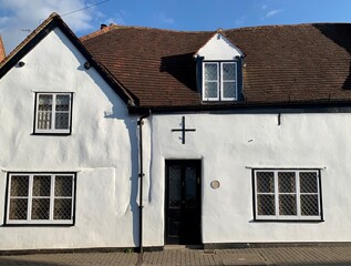 Street view of St Albans, Hertfordshire, United Kingdom. Facade of old house. Fragment of facade of medieval house with stained glass windows and tile rooftop in old town.