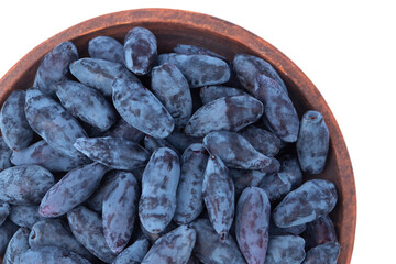 edible honeysuckle berries lie in a brown clay plate isolated on a white background