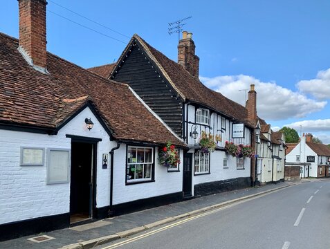 ST ALBANS, ENGLAND - 23.08.2021. Facade Of The Six Bells Quaint And Historic Tudor Pub In British Medieval Town With Cherry Flowers In Hanging Baskets Along Half-timbered Walls.