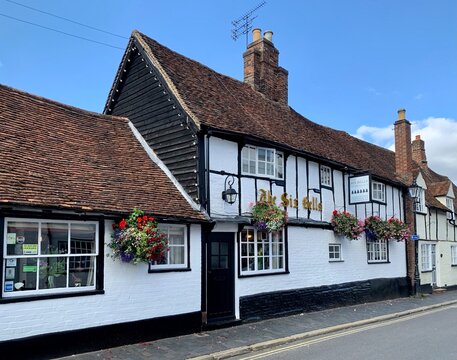 ST ALBANS, ENGLAND - 23.08.2021. Facade Of The Six Bells Quaint And Historic Tudor Pub In British Medieval Town With Cherry Flowers In Hanging Baskets Along Half-timbered Walls.