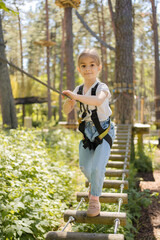 Rope park. Child girl having fun at adventure park. 