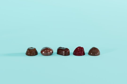Various chocolate pralines on a blue background. Concept of making chocolate, eating pralines. 3D render, 3D illustration.