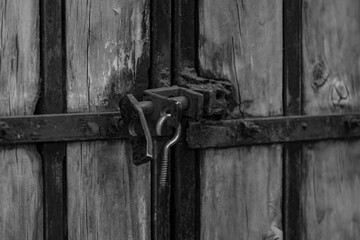 metal lock of a wooden gate in black and white