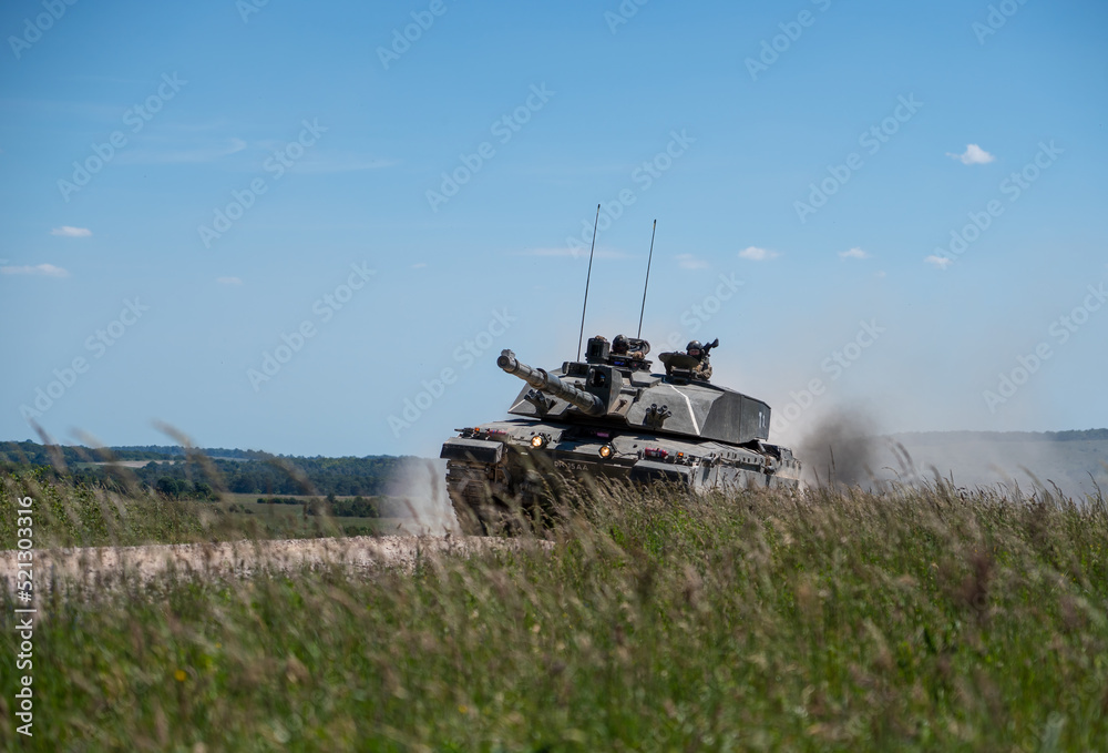 Wall mural closeup of a british army challenger 2 ii fv4034 main battle tank in high speed action, blue sky wil