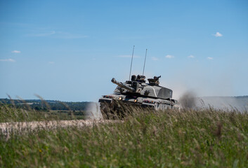 Fototapeta premium close-up of a British army Challenger 2 ii FV4034 main battle tank in high speed action, blue sky