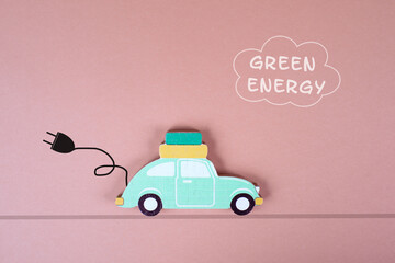 Small green electric car with a cable for recharging, vacation trip with eco power
