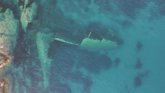 Aerial view of a sunken shipwreck near the rocks along the coast in Pomonte, Elba Island, Tuscany, Italy.