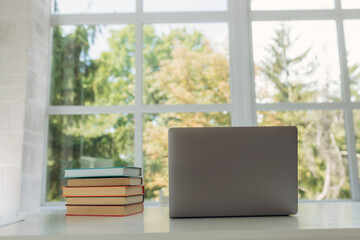 Fototapeta premium Close up of books and laptop on table at home. Student's place of study. Place for your text